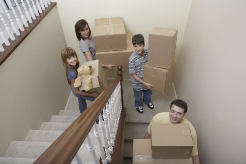 Removal team carrying furniture through a narrow staircase